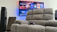 FlexiSpot XRC5 with an Xbox controller in front of a TV showing the SteamOS gaming interface.