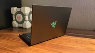 The Razer Blade 14 (2025) on a desk in front of a Companion Cube from Portal.